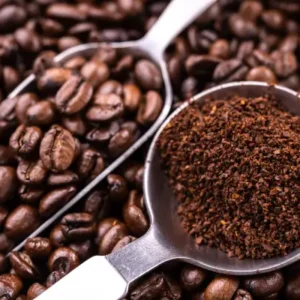 Ground coffee and beans in metal scoops