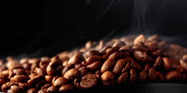 Steaming roasted coffee beans in dark container